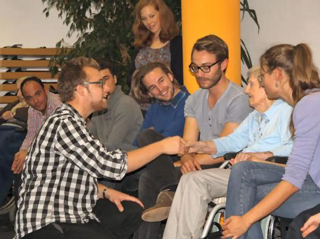 Poetry-Slammer Lars Ruppel reicht einer Bewohnerin die Hand, spricht sie persönlich an.