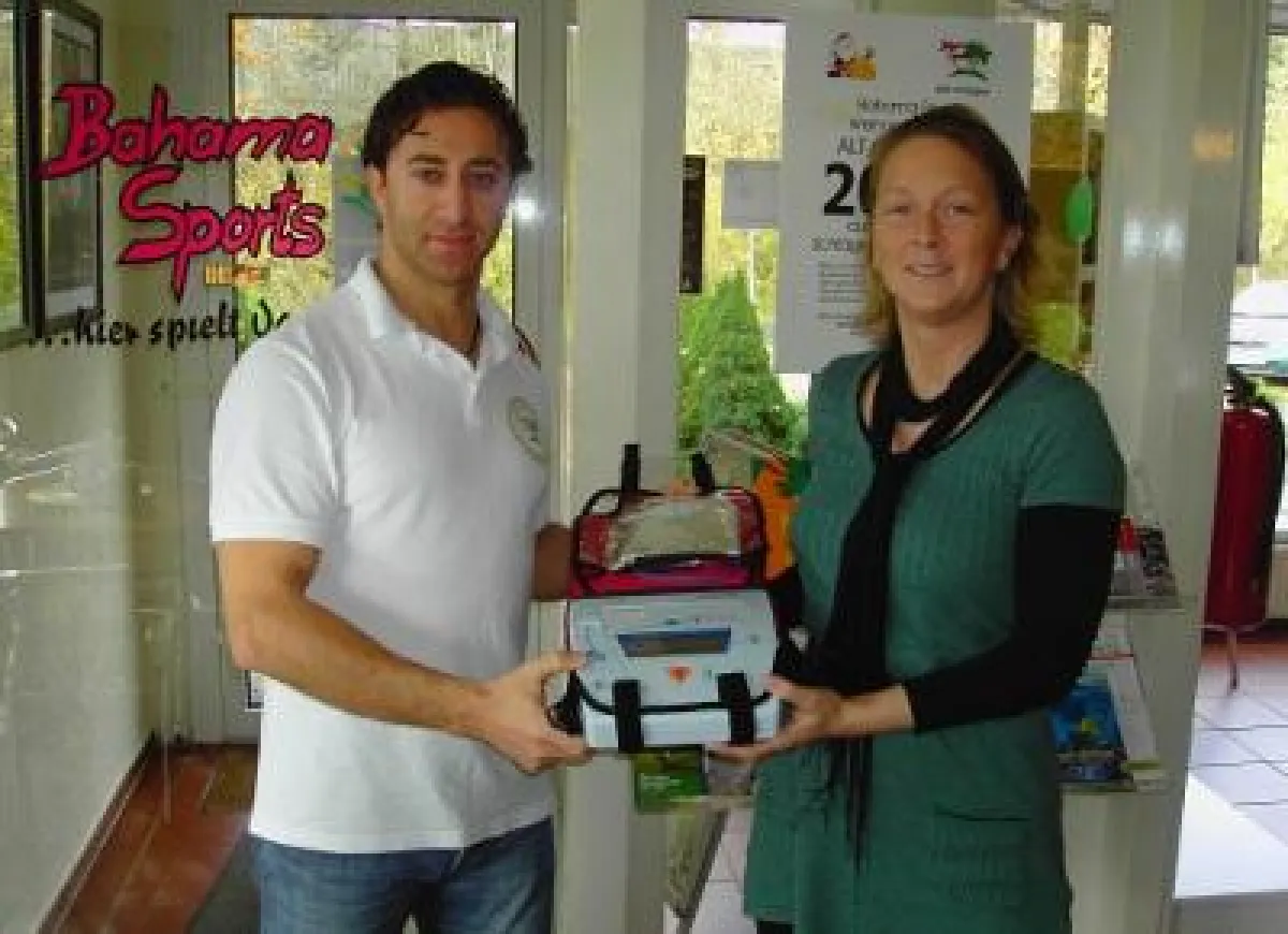 Christiane Brinkmann und Dipl. Sportlehrer Andravus Eker präsentieren einen der vier Defibrillatoren bei Bahama Sports.