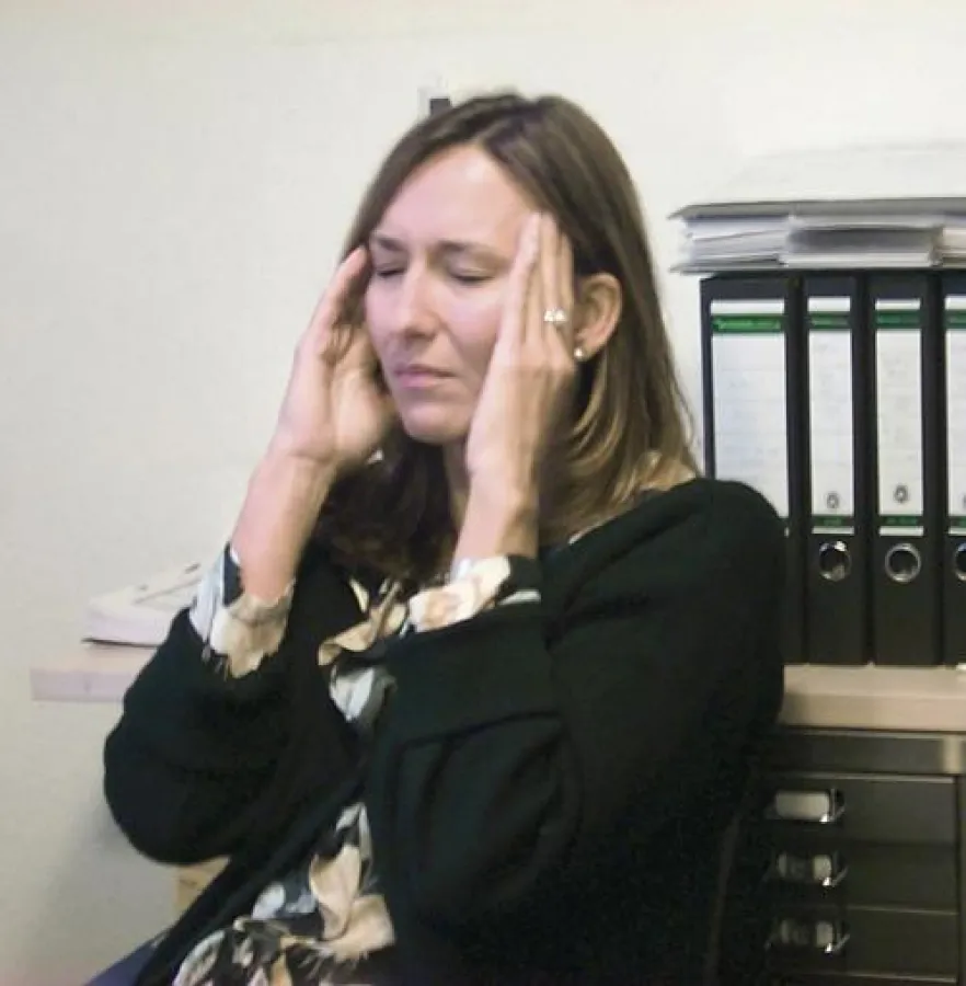 Muskelverspannungen durch überwiegend sitzende Tätigkeiten und Stress können Kopfschmerzen auslösen.