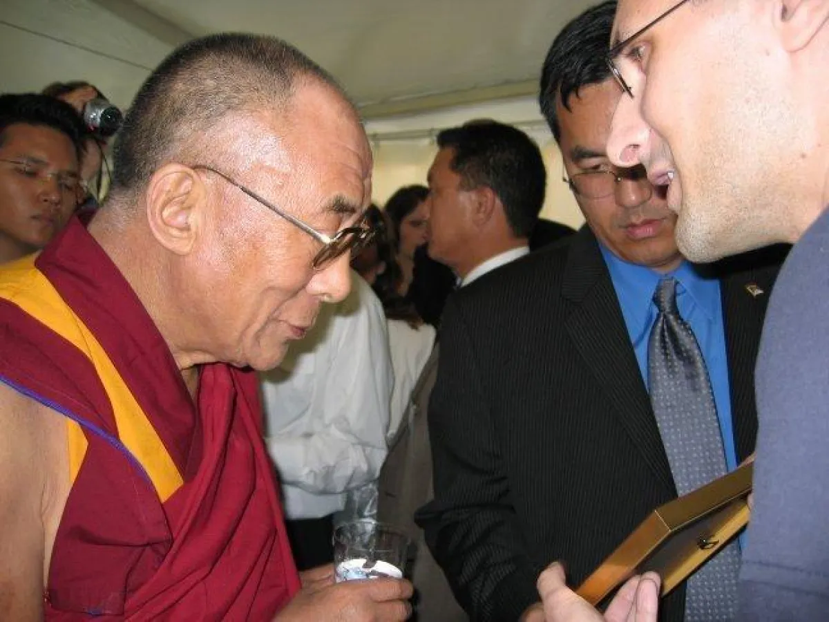 Alexander Rostami überreicht dem Dalai Lama ein Tageshoroskop.
