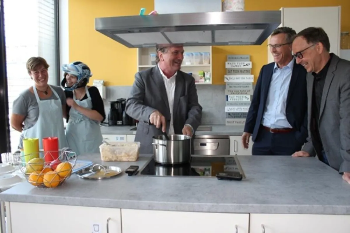 Minister Manfred Lucha (mitte) kocht Schinkennudeln im KuBiQu