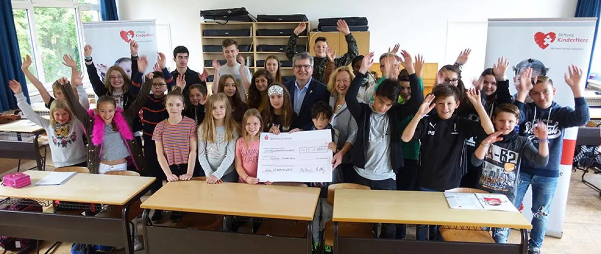 Peter Renzel (Stadt Essen) und Sylvia Paul (Vorstand Stiftung KinderHerz) mit den Klassensprechern.