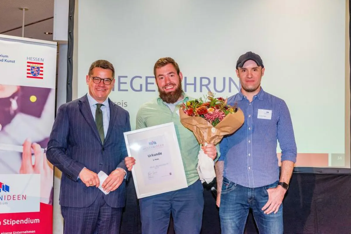 Josias Plock (Mitte), Master-Student der EJosias Plock (Mitte) belegt den 3. Platz, Wissenschaftsminister Boris Rhein (l.) und der Finalist des vergangenen Jahres, Stefan Merkel (r.) gratulieren. (Fot