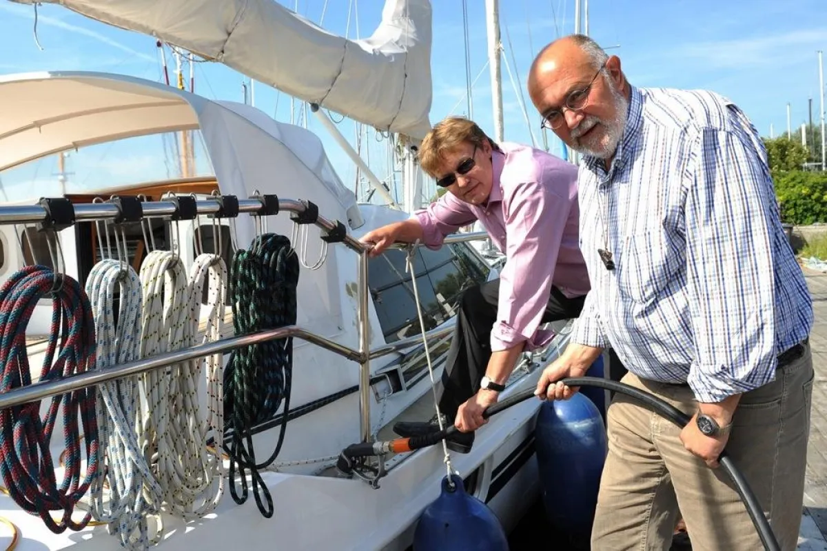PROGAS-Verkaufsleiter Lothar Andert (links) und Burkhard Kähler, Geschäftsführer der Werft Hooksiel, demonstrieren die Betankung eines Bootes mit dem umweltschonenden Flüssiggas. Foto: PROGAS