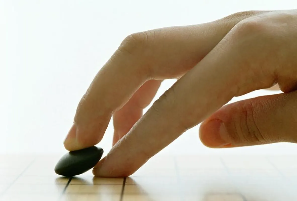 Setzen eines Go Spielsteins, Foto: Martin Chrz