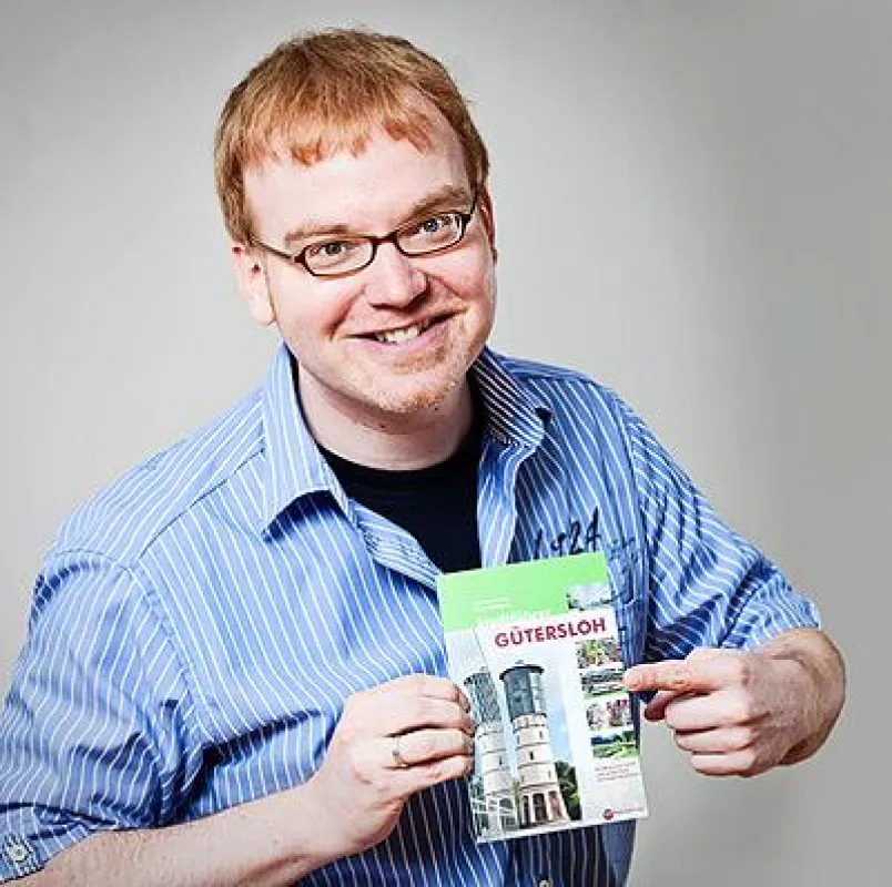 Autor Matthias Borner mit dem Gütersloher Stadtführer aus dem tpk-Regionalverlag