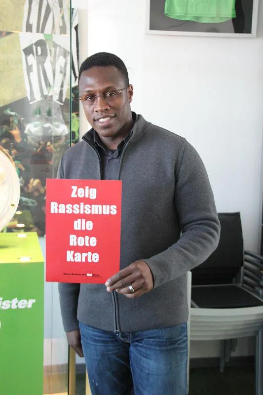 Pablo Thiam posiert mit der roten Karten gegen Rassismus