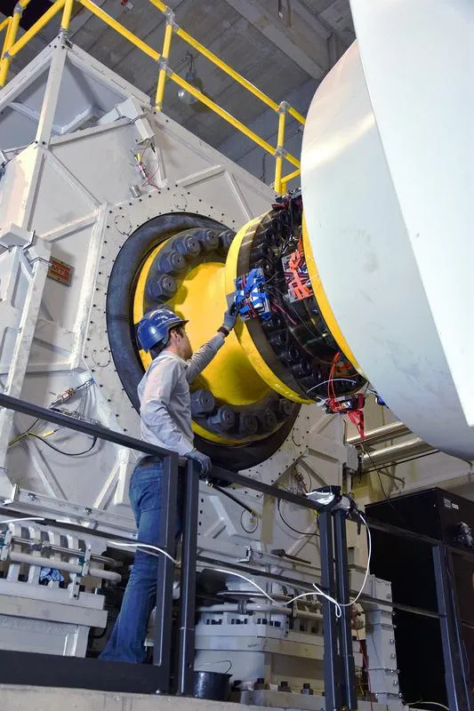 Ein PTB-Kollege überprüft die Messtechnik, die an dem Drehmomentsensor befestigt ist, und wechselt die Akkus, die einen eigenständigen Betrieb ermöglichen. ((Abb.: Physikalisch-Technische Bundesansta