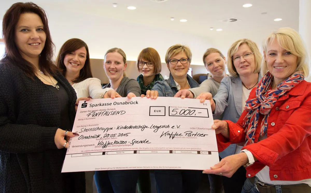 Mitarbeiter von Kaffee Partner mit einem stolzen 5.000 EUR Scheck