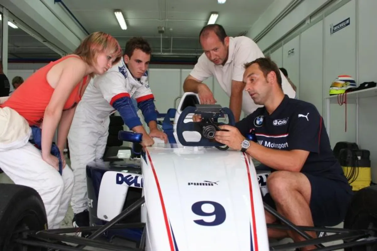 Jörg Müller erklärt den Youngsters Fabio und Jackie das FBMW Lenkrad