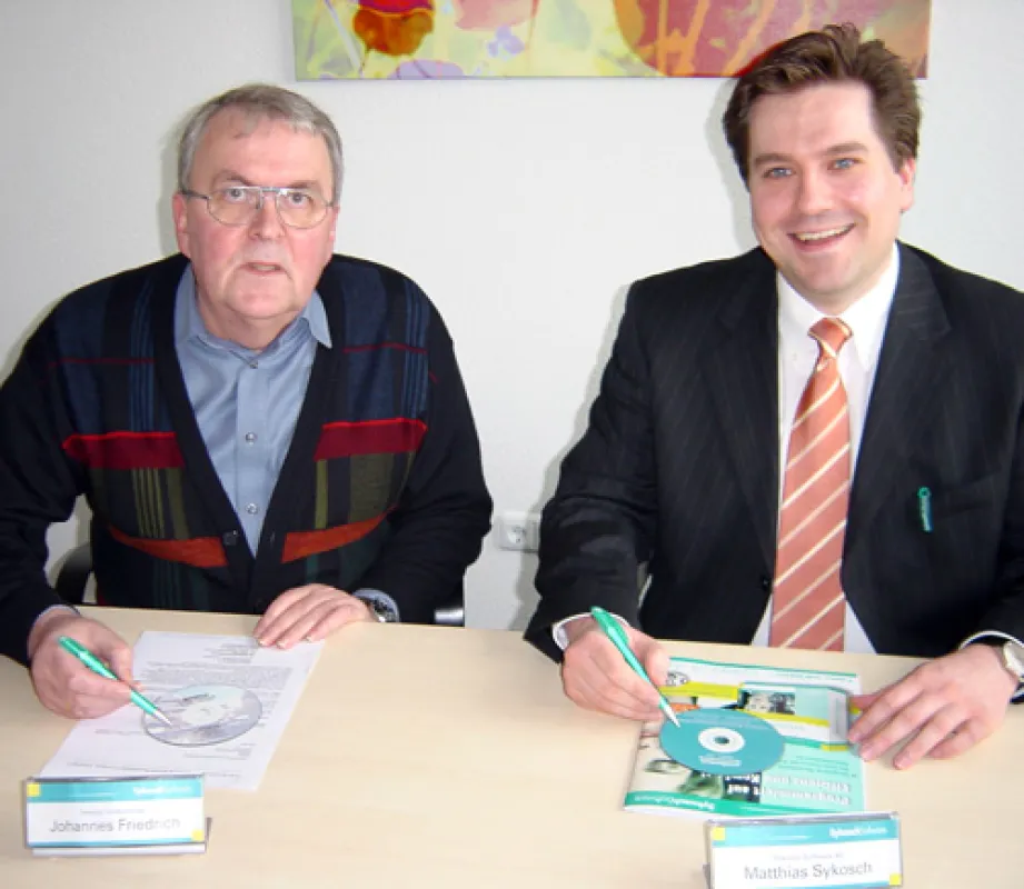 Symbolische Vertragsunterzeichnung auf CD (v. li.): Johannes Friedrich (Geschäftsführer Friedrich Datenverarbeitung GmbH) überträgt seine „DOMUS-Hausverwaltung“ an Matthias Sykosch (Vorstandsvorsitzen