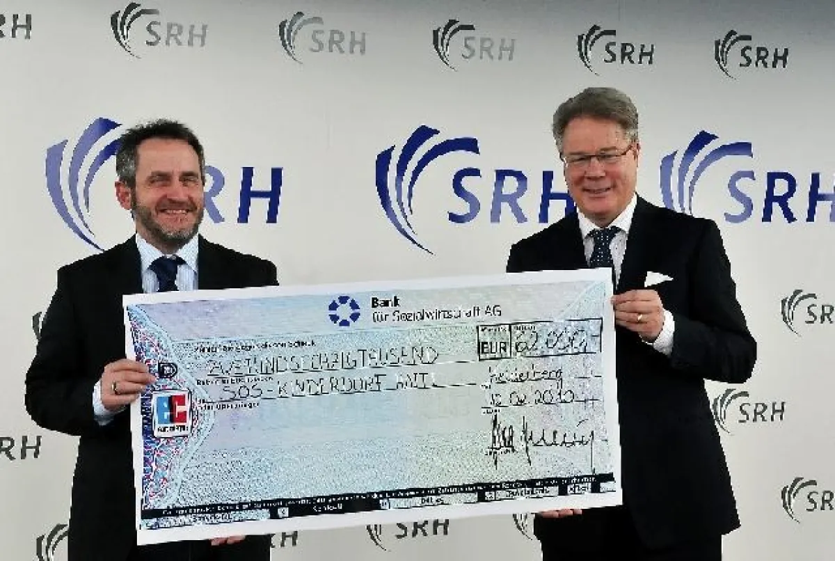 SRH Vorstandsvorsitzender Prof. Klaus Hekking (rechts) übergibt die Spende an Hans-Peter Fromm (links) von SOS-Kinderdorf e. V.