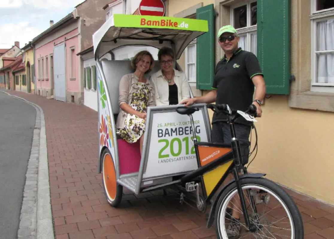 Karin Seehofer im LGS-TaxiBike vor dem Gärtner & Häcker-Museum