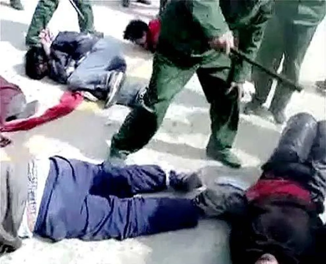 Ein Bild aus dem Video: Chinesische Polizisten mißhandeln gefesselte Tibeter