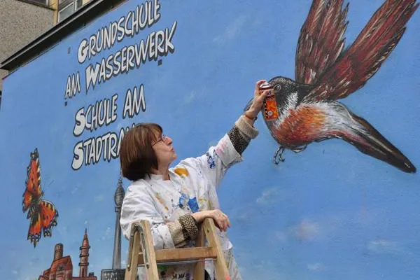 Bild: Schulleiterin besprüht Schule