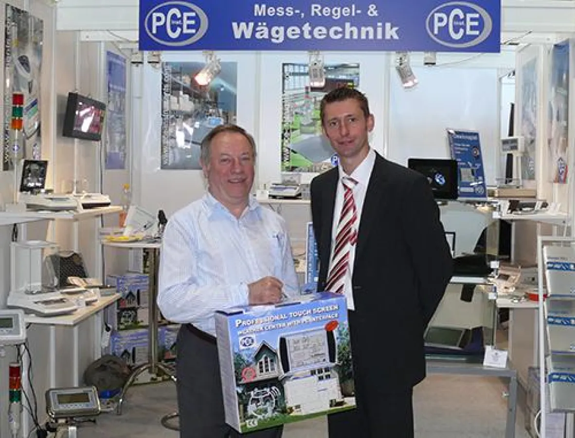 PCE Mitarbeiter überreicht eine Wetterstation PCE-FWS 20 dem glücklichen Gewinner