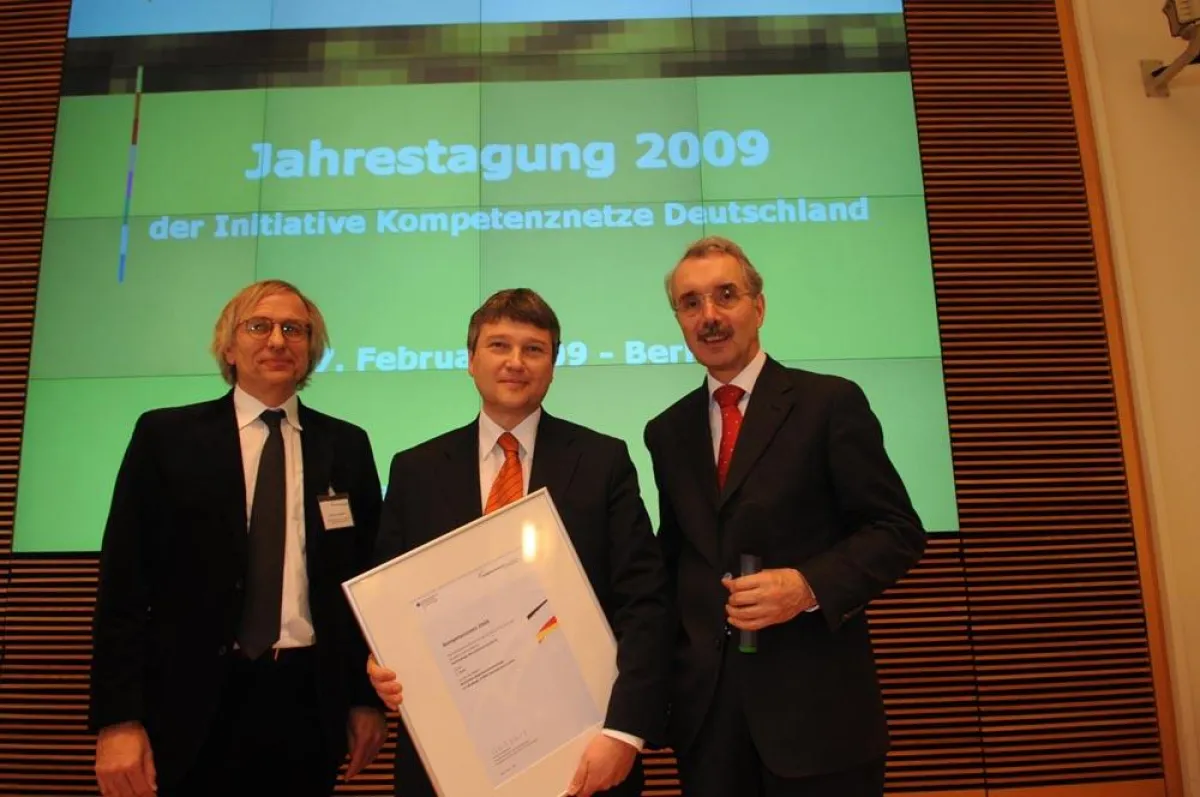 Prof. Dr. Jörg Sydow (links) und Staatssekretär Hartmut Schauerte (rechts) gratulieren Dr. Klaus Eichenberg