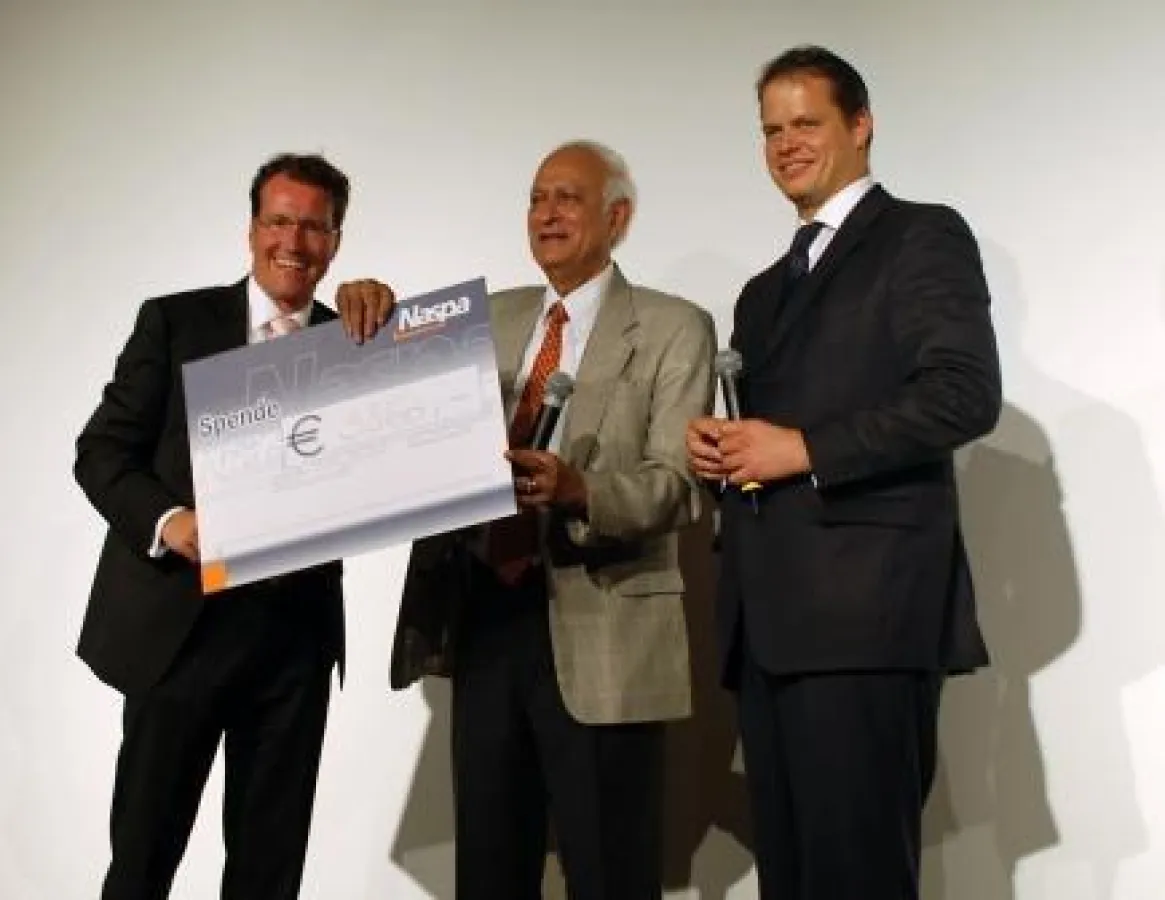 Dirk Martin (l.) und Harald Popp (r.) überreichen Bidhan Roy den Scheck über 3860 Euro zugunsten der Gandhi Kinderhilfe.