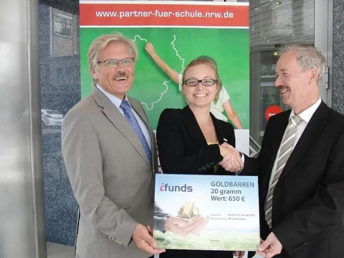 Bild: ifunds germany überreicht glücklicher Gewinnerin den Goldbarren