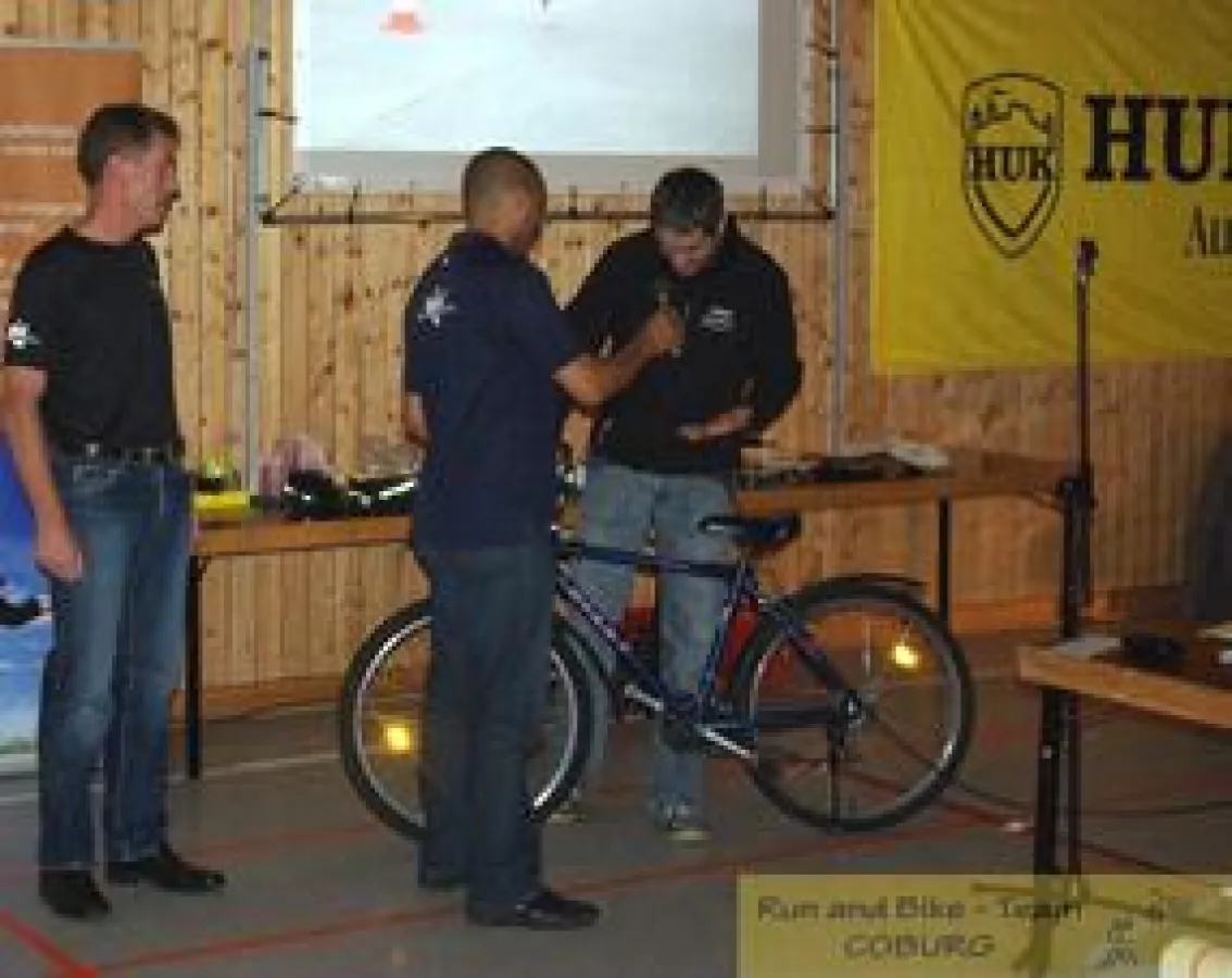 Stephan Pelzl (rechts) übergibt an Clemens Mulokozi (Mitte) von Jambo Bukoba ein gespendetes Rad
