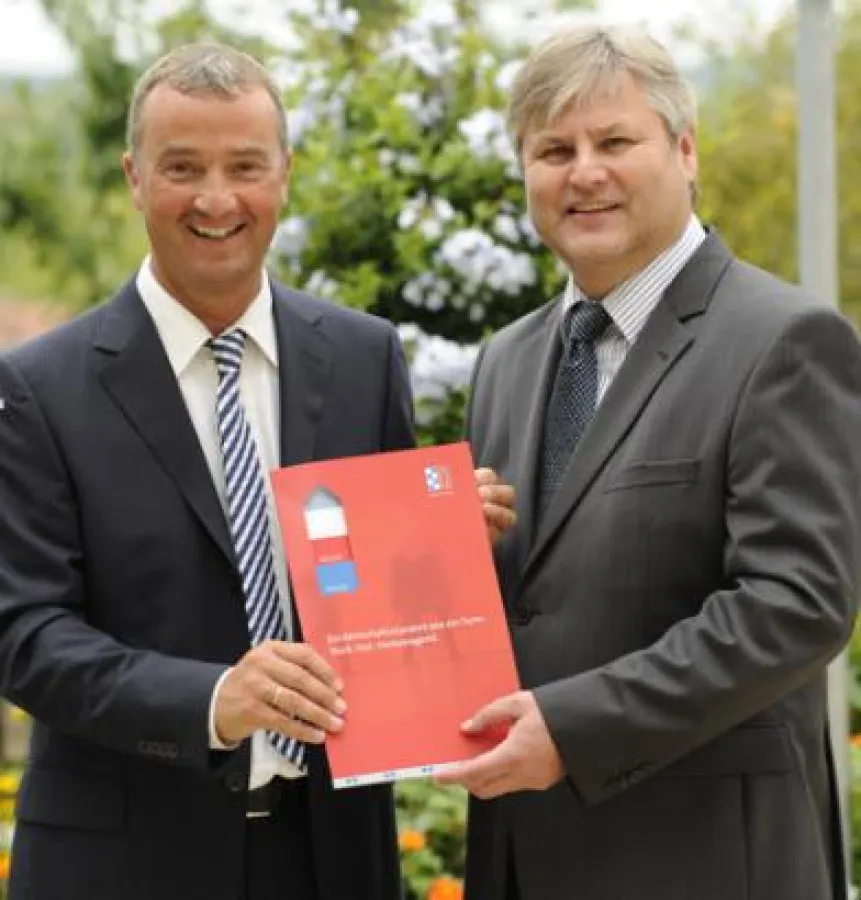 Günzburgs OB Gerhard Jauernig und Contrast-Geschäftsführer Wolfgang Strobl präsentieren die Standortmappe. Foto: B. Weizenegger