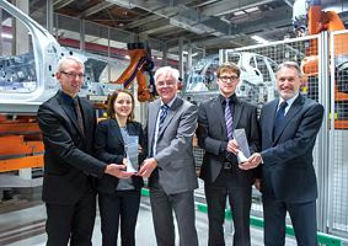 Arne Lakeit (links) und Alois Brandt (rechts), beide AUDI AG, und das TU-Siegerteam.