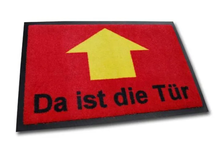 Bild: Richtungsweisend: Fussmatte «Da ist die Tür» bei geschenkbox.de