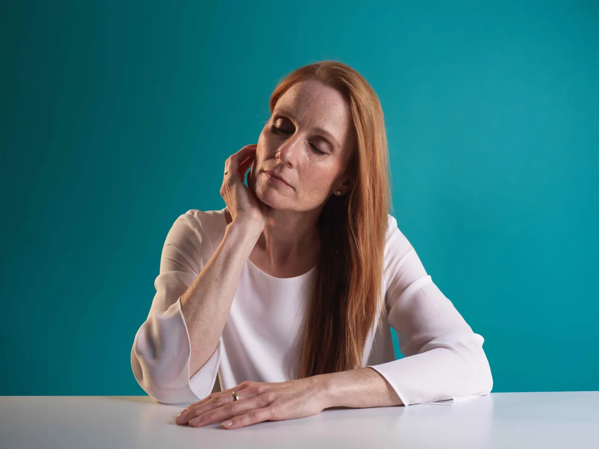 Frau mit Wechseljahresbeschwerden am Arbeitsplatz (© Besins Healthcare Germany)