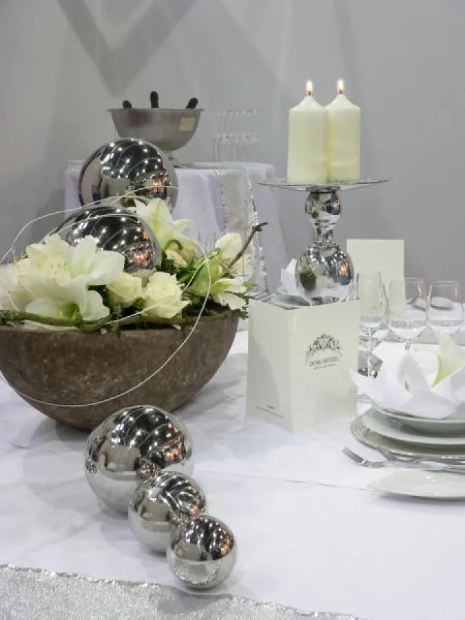 Silberne Accessoires und Stumpenkerzen mit dem RAL-Gütezeichen veredeln jede Festtafel. Foto: Gütegemeinschaft Kerzen; Deko: Dom-Hotel, Köln