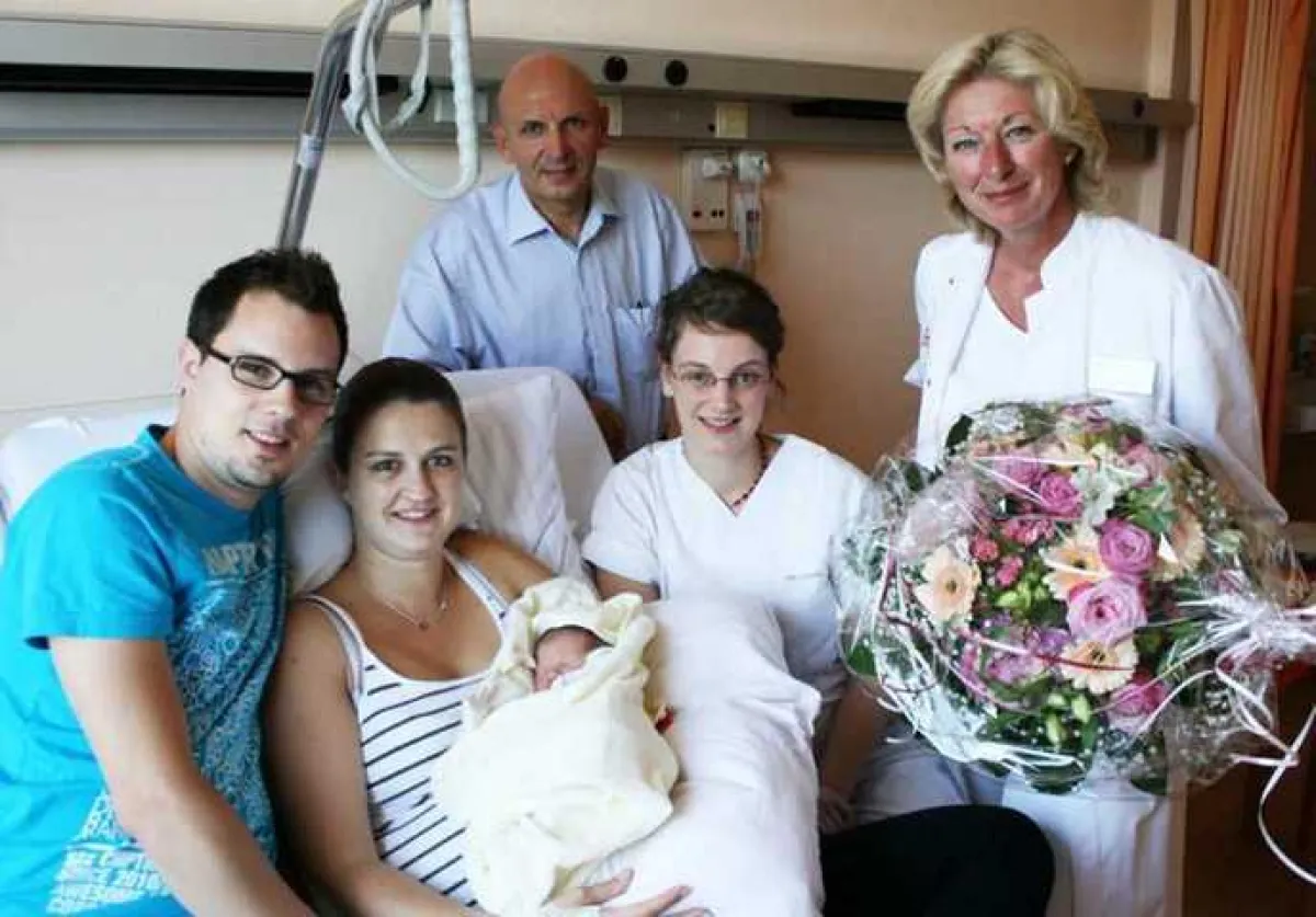 Klinikum-Geschäftsführerin Dr. Astrid Gesang, Hebamme Verena Becher und Dr. Gerd Degoutrie gratulieren Stefanie & Benjamin Basler