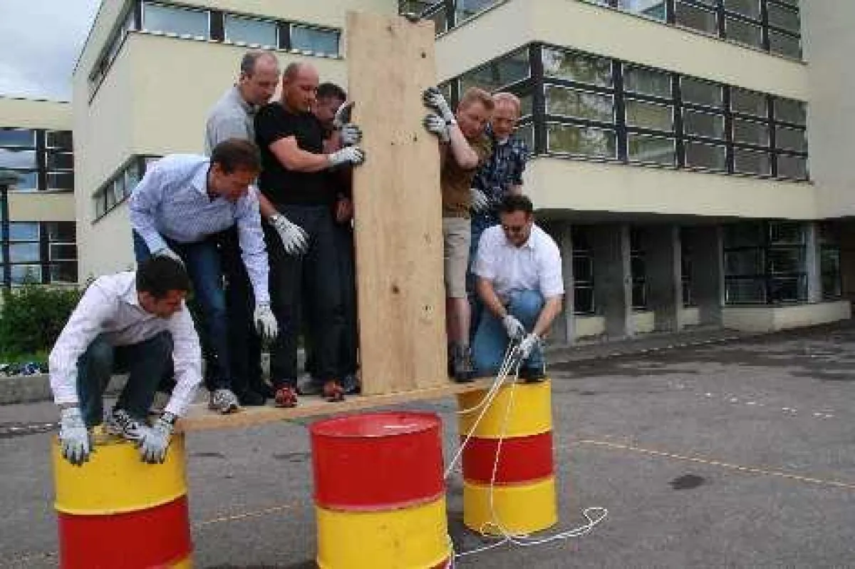 Brückenbau aus Brettern, Balken, Getränkekisten und Ölfässern schweißt das Studienteam zusammen.