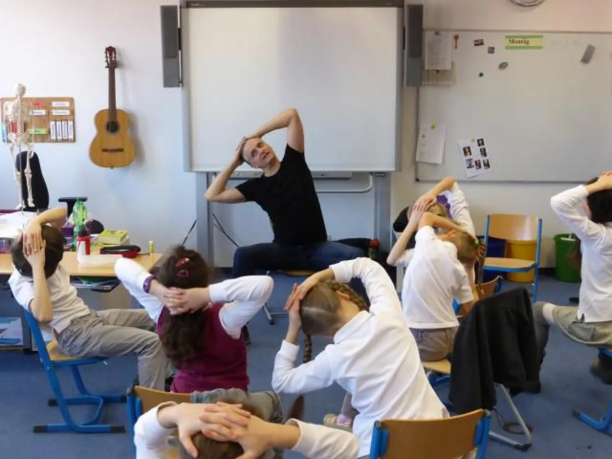 Das Rückentraining Gyrokinesis kann einfach auf dem Stuhl sitzend durchgeführt werden