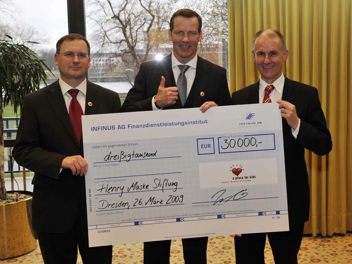 Die Vorstände der INFINUS AG Jens Pardeike und Wilhelm Hartmann mit Henry Maske bei der Scheckübergabe