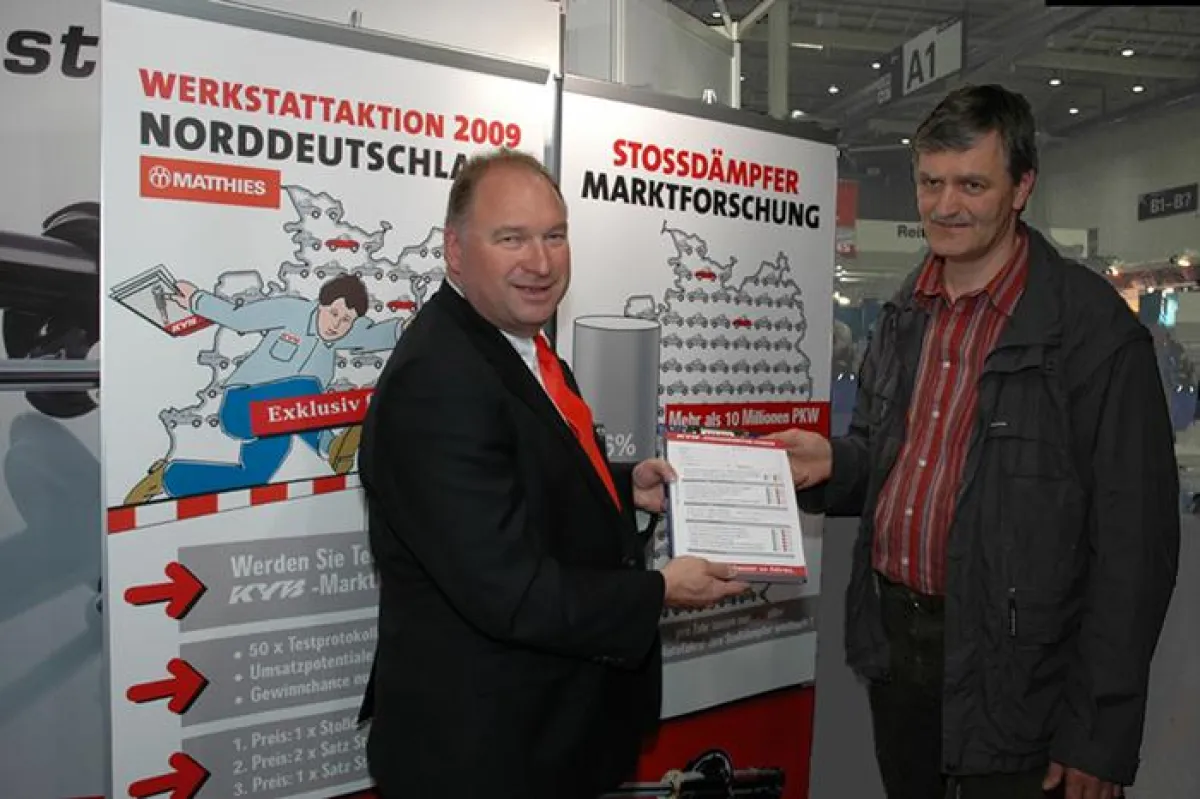 Vertriebsleiter Thomas Kleist von Matthies überreicht Henry Stefan, Geschäftsführer von Autotechnik RE-EL-DI in Rostock-Elmenhorst, die Teilnahmeunterlagen der Stoßdämpfer-Marktforschungsaktion Fo