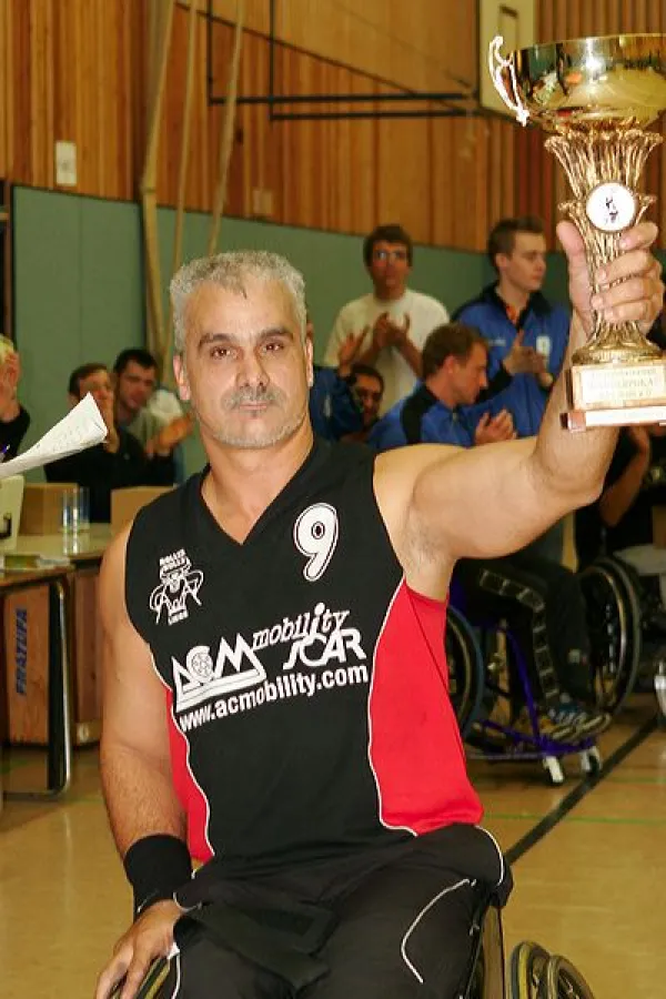 Der Kapitän der Roller Bulls Liege mit dem Wanderpokal des Kick Off Rollstuhlbasketballturniers