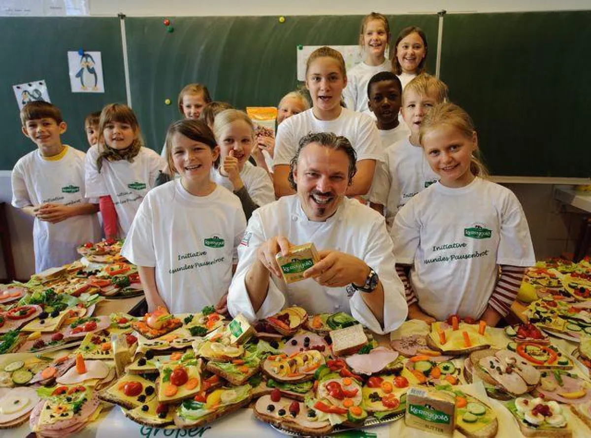 Sternekoch Peter Scharff bereitet mit Kindern der Wilhelm-Busch-Grundschule Pausenbrote zu