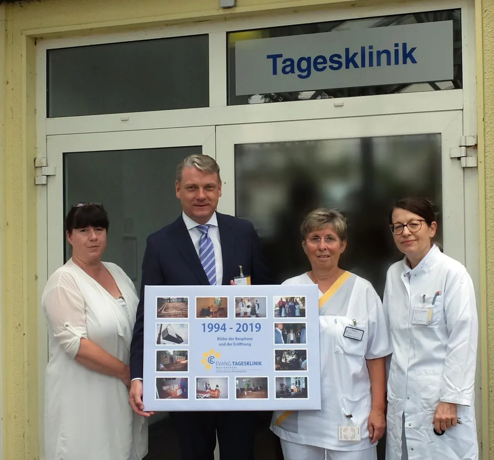 Geschäftsführer Meyer überreicht Schwester Lange eine Collage zur Erinnerung