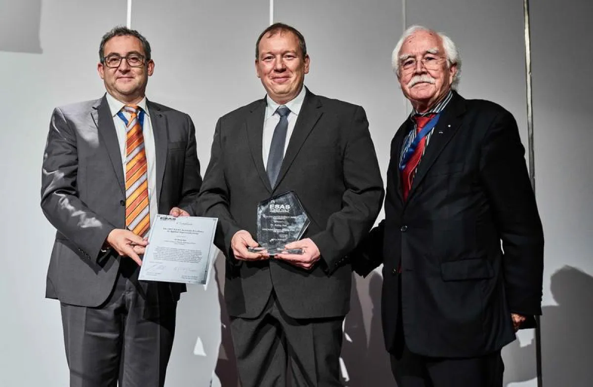 Bernhard Holzapfel vom KIT Karlsruhe (links) und Herbert C. Freyhardt von der Universität Houston/USA (rechts) überreichen den Preis an Ronny Stolz.  (Die Bildrechte liegen bei CERN und EUCAS 2017.)