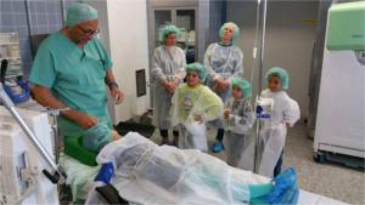 Dr. Peter Rensmann mit seinen jungen Zuhörern, auf dem OP-Tisch liegt Elif Su.