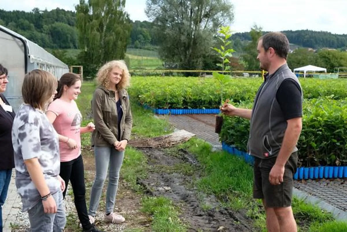 Markus Joos, Fachkraft für Arbeit und Bildung, und die Schülerinnen beim Besuch der Baumschule.