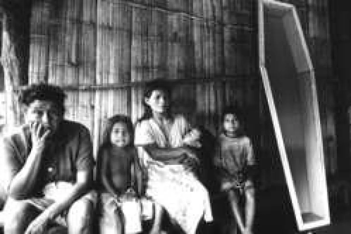Eine brasilianische Guarani-Familie sitzt neben einem Sarg. © Joaó Ripper/Survival