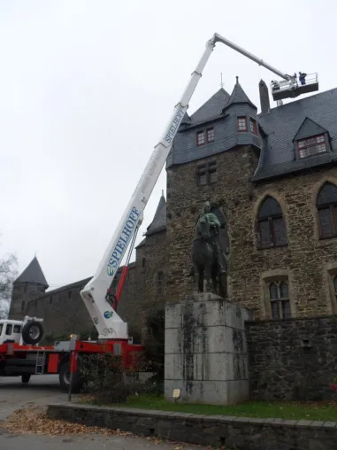 Bild: Zentimeterarbeit am Schlosstor: Historische Kamine mit Arbeitsbühne von System Lift begutachtet