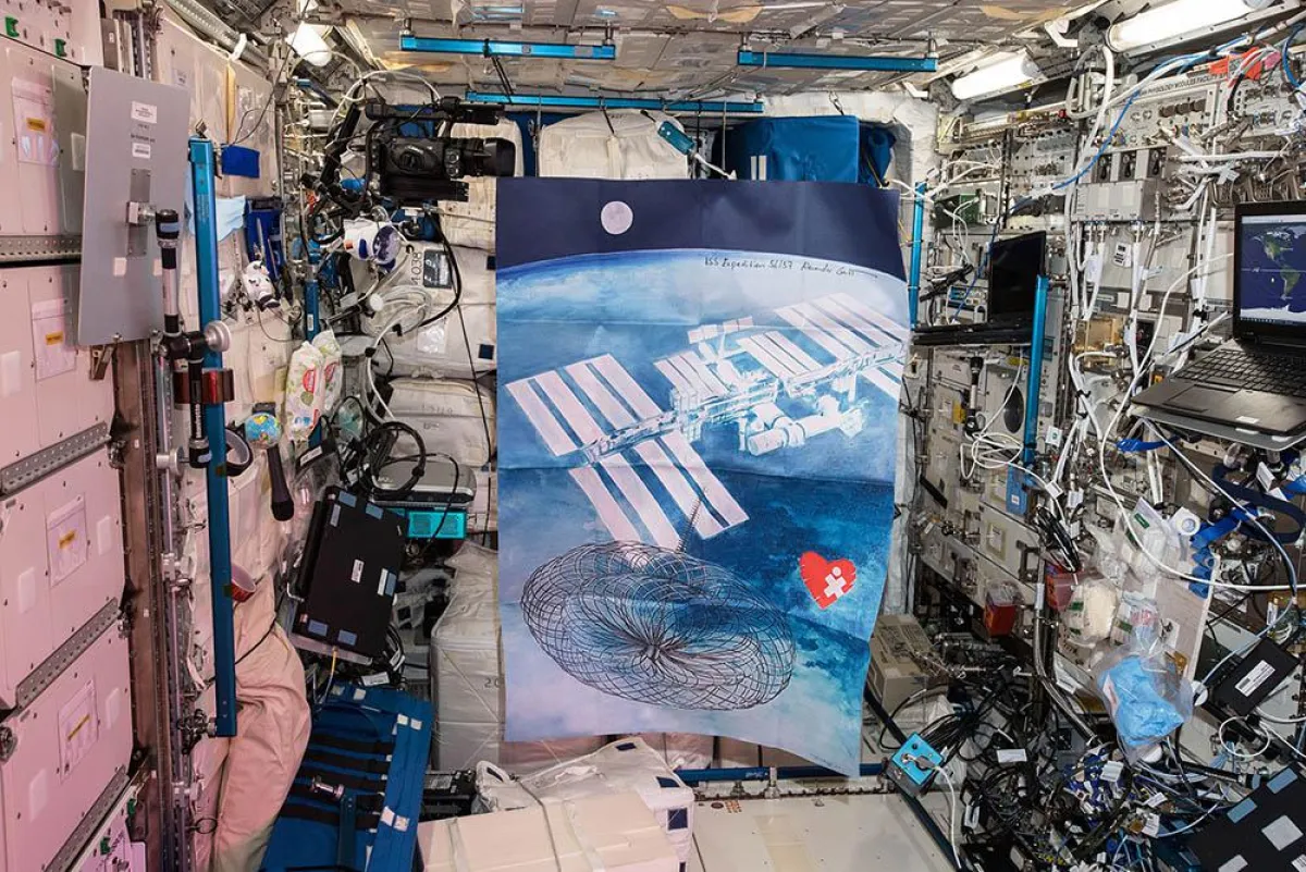 Flagge mit Motiv ?Drei Geschichten vom Mut? freischwebend auf der ISS, signiert von Alexander Gerst.