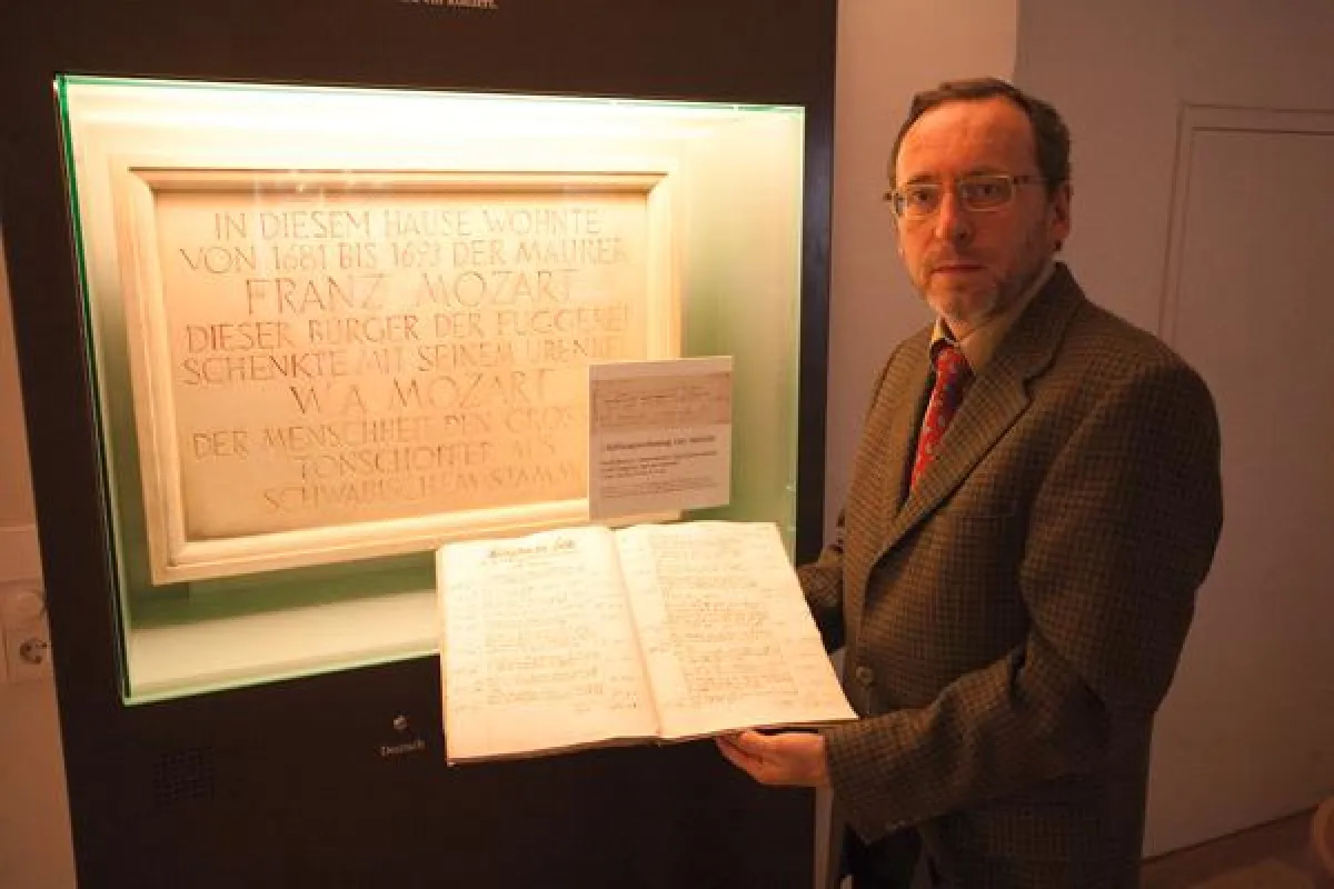Franz Karg, der Archivar der Fugger-Archivs, mit einer der Stiftungsrechnungen, die belegen, dass schon der erste nach Augsburg eingewanderte Vorfahre Wolfgang Amadé Mozarts – David Mozart d.J. – für 