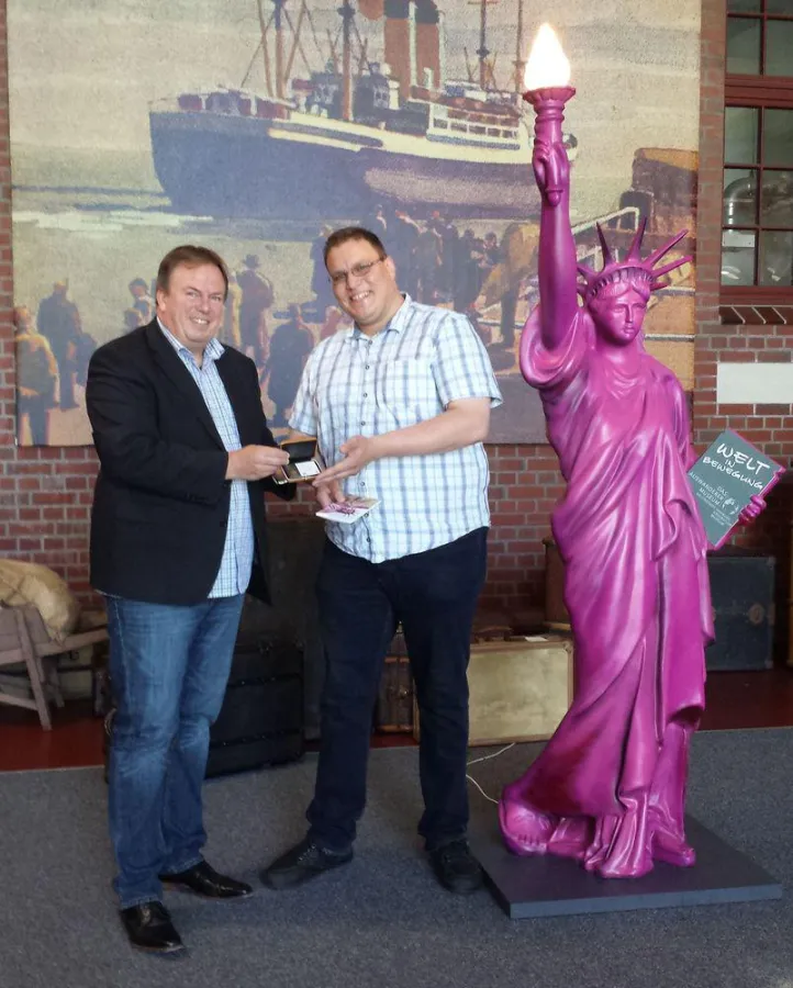 Volker Reimers, Geschäftsführer der BallinStadt, überreicht dem glücklichen Gewinner das Goldstück