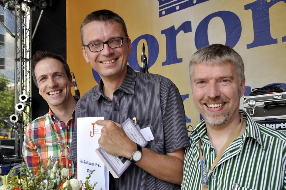 Rexhausen-Preis-Verleihung auf der Hauptbühne des CSDs in Frankfurt am Main: Moderator Mathias Münch, Gewinner Michael Lohse, Jury-Mitglied Arnd Riekmann (von links); Foto: Monika Müller