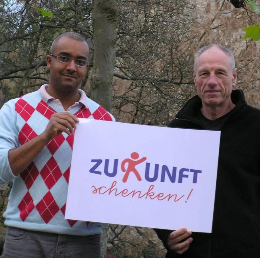Designer Alfred Ernst (links) übergibt dem 1. Vorsitzenden des Kinderschutzbund, Jean-Dominique Risch das offizielle Logo von ZUKUNFT SCHENKEN
