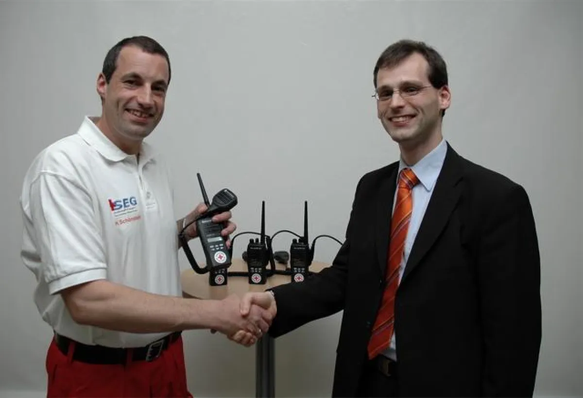 SEG-Einsatzleiter Hermann Schönstein (links) nimmt die neuen Funkgeräte von Christian Neusser, Geschäftsführer der spendenden VEND consulting GmbH, in Empfang.