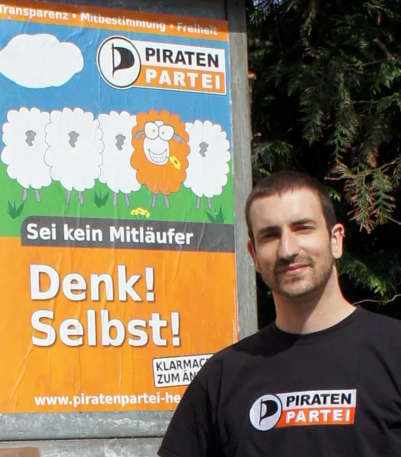 André Hoffmann, Landtagskandidat der Piraten Hessen vor dem ersten Wahlkampfplakat in Biebesheim