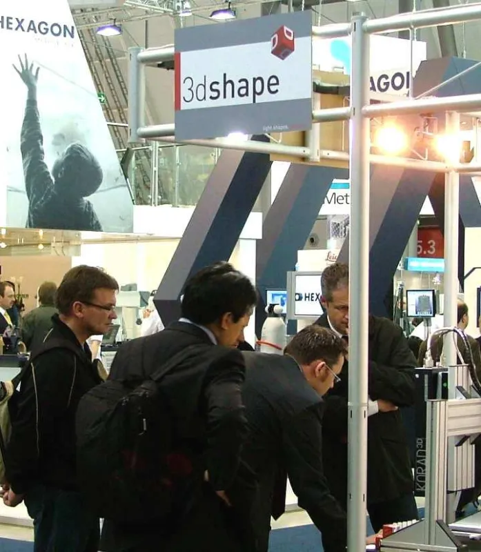 Besucher am Messestand der 3D-Shape GmbH. Produktentwickler Reinhard Gross (2. v.r.) erläutert die Funktion seines optischen Sensors KORAD3D.